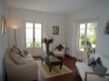 The villa living room with one set of French doors leading onto the alfresco dining terrace and the other set providing a stunning view across the valley, past the Four Seasons Golf Resort and beyond to the mountains.